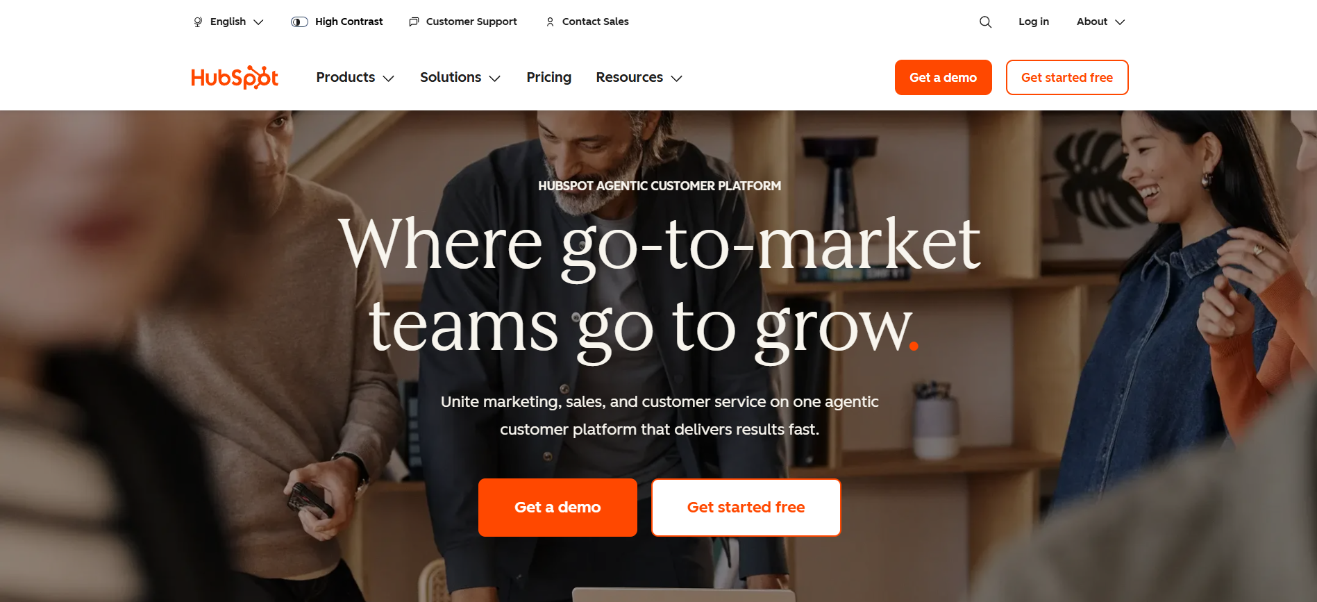 HubSpot homepage depicting a team collaborating in an office setting, with the headline "Where go-to-market teams go to grow," and CTA buttons.